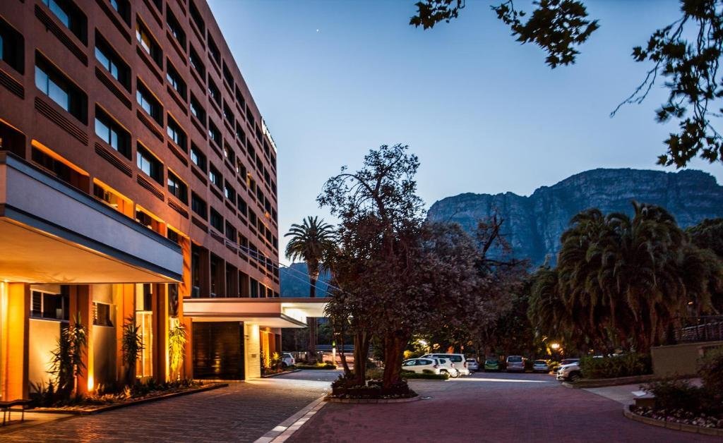 Southern Sun Newlands hotel exterior at twilight with Table Mountain backdrop