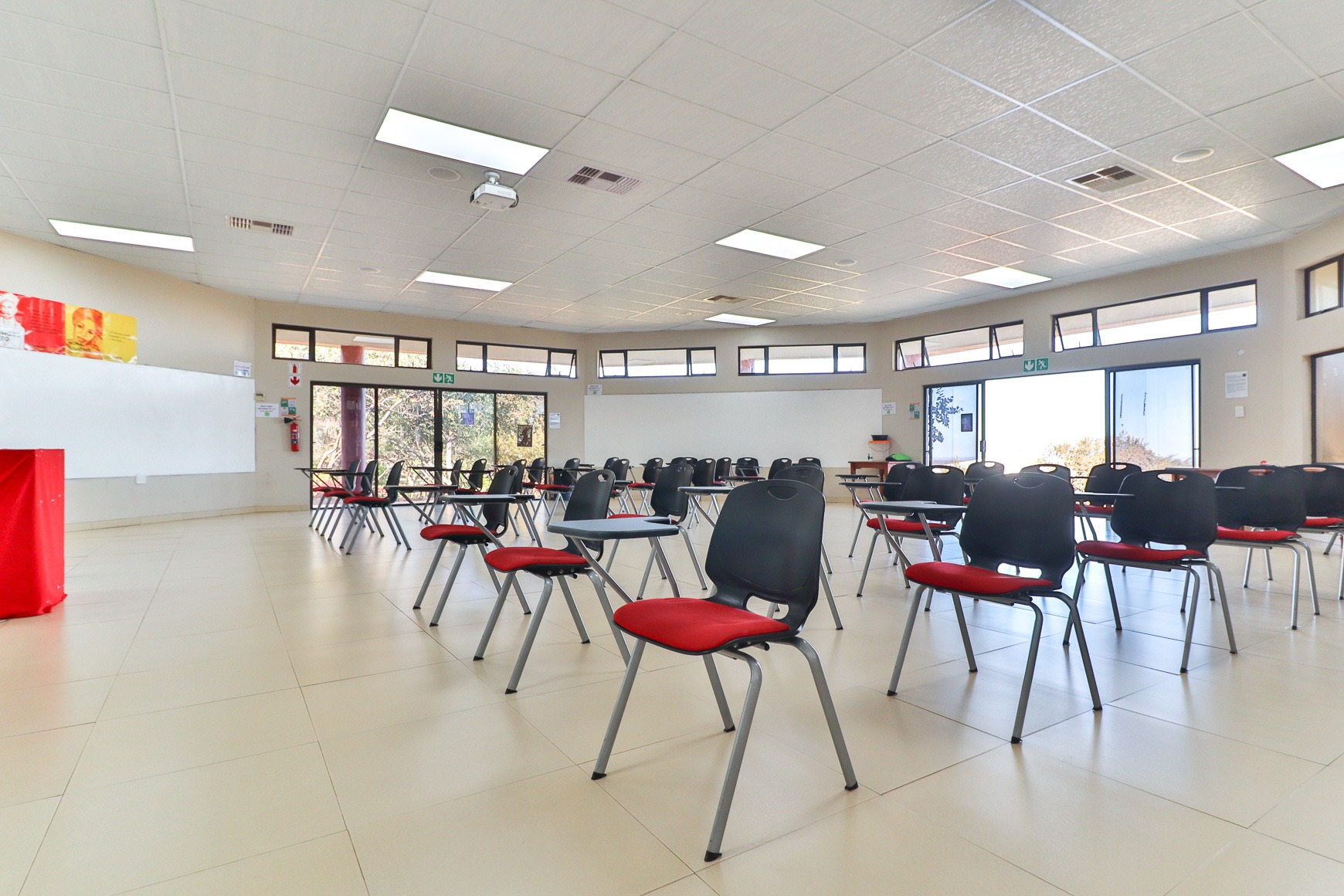 Conference room in classroom layout with projector and whiteboards at Thuto Centre