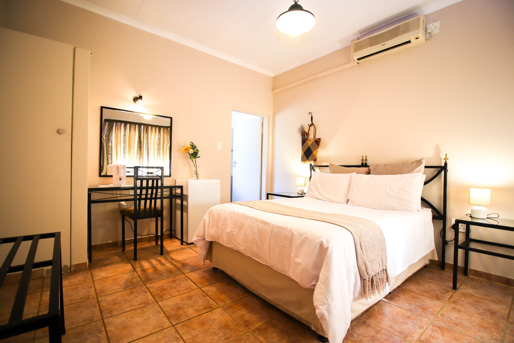 Deluxe en-suite bedroom with air-conditioning and work desk at Thuto Centre